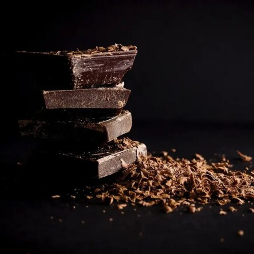 Stack of dark adaptogenic chocolate bars with rich shavings.