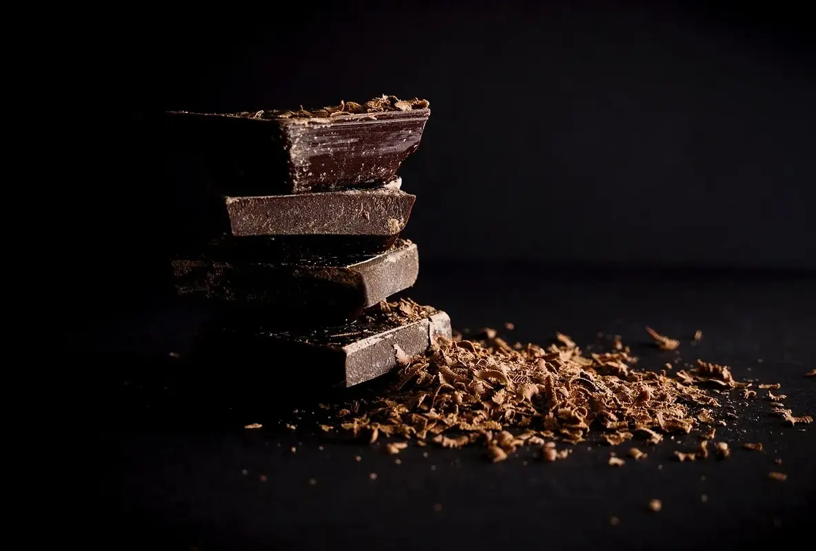 Stack of dark adaptogenic chocolate bars with rich shavings.